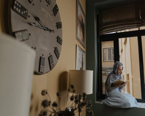 Woman reading a book near a large window with soft natural light